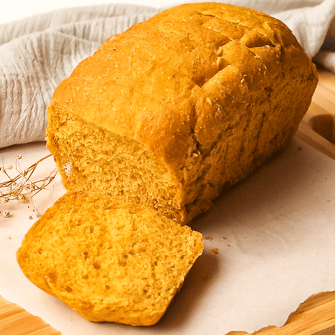 Pão de forma de abóbora orgânica sem açúcar fofinho e saudável fatiado sobre a mesa para toda a família.